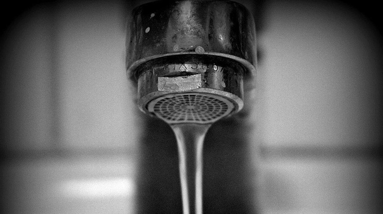 Un grifo abierto en el que cae el agua.