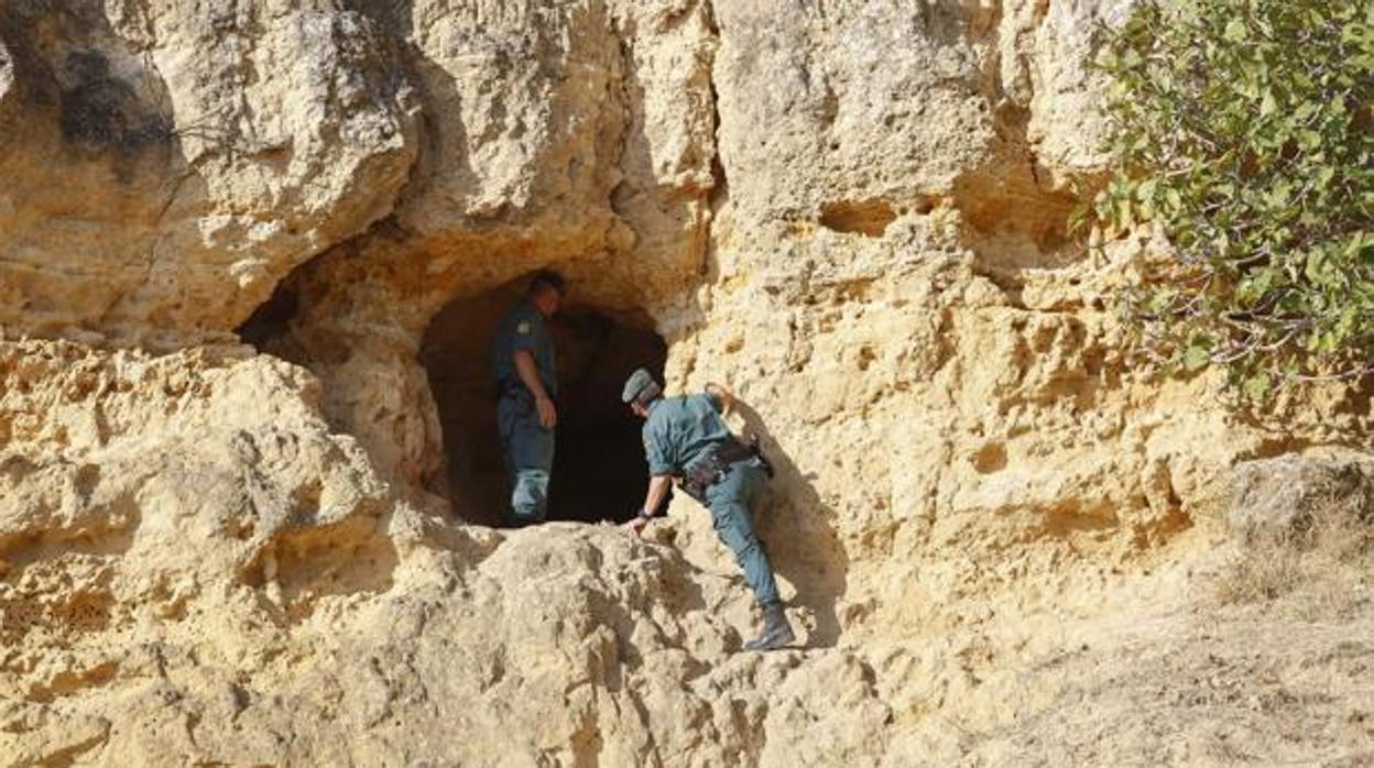 Dos agentes verifican el interior de una cueva durante las labores de búsqueda que se desplegaron en Carmona