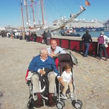 El almirante con su nieto y bisnieto y el Elcano al fondo.