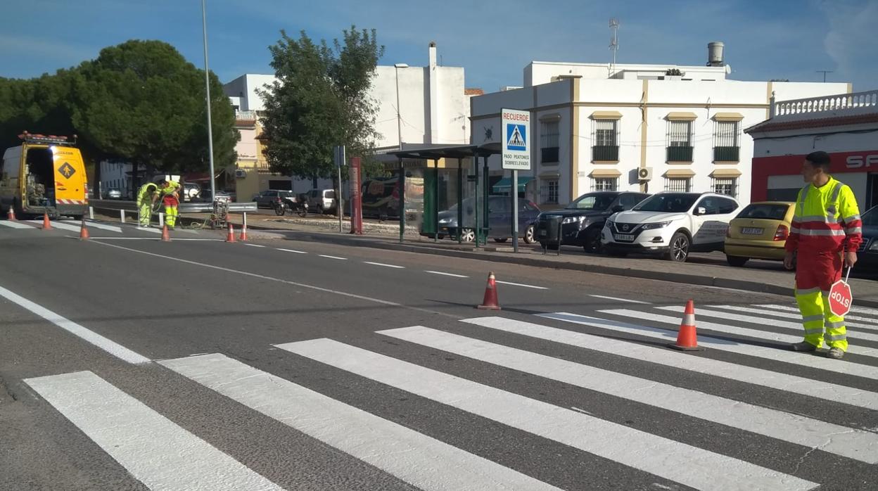 Un operario controla el tráfico sobre un paso de peatones de la travesía de Burguillos