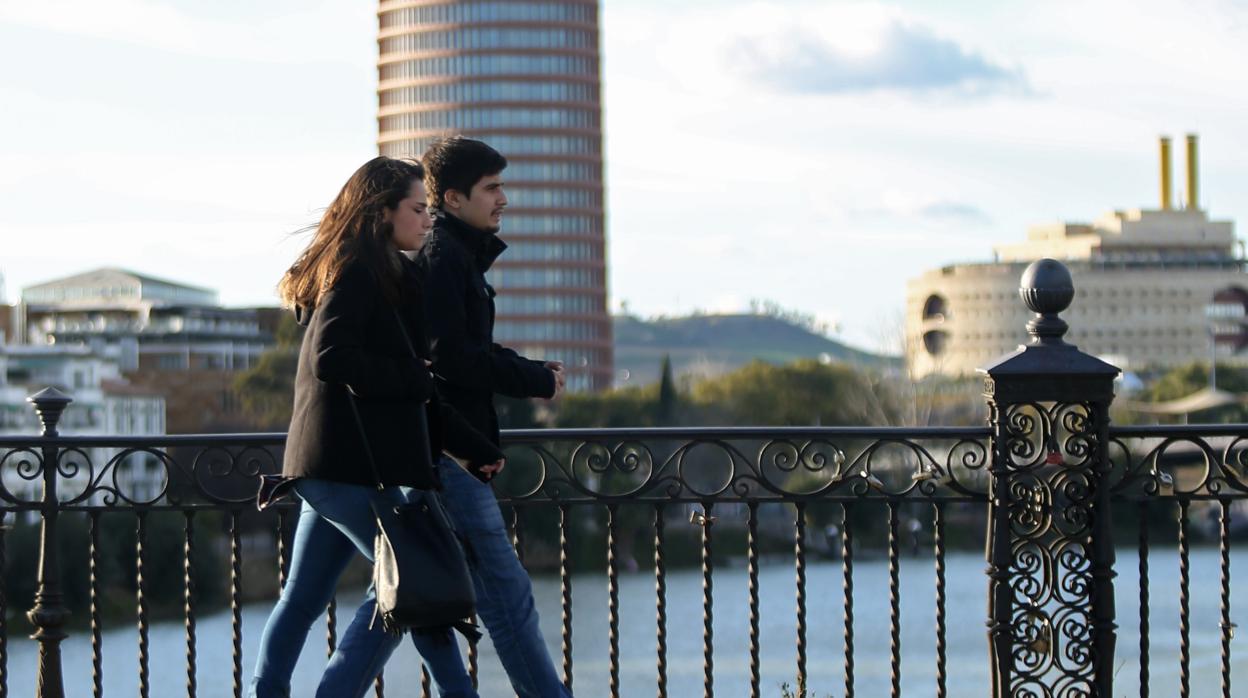 Una pareja pasea por el puente de Triana