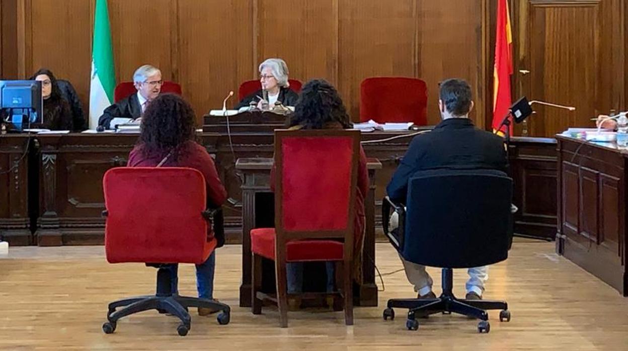 Los tres acusados sentados delante de la magistrada en el juicio con jurado