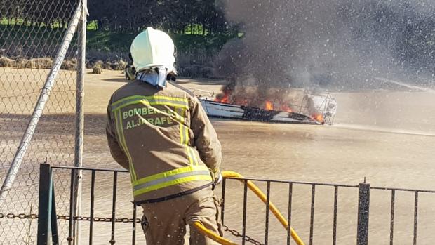 Los bomberos sofocan las llamas de una embarcación que ardía en el río Guadalquivir junto a Gelves