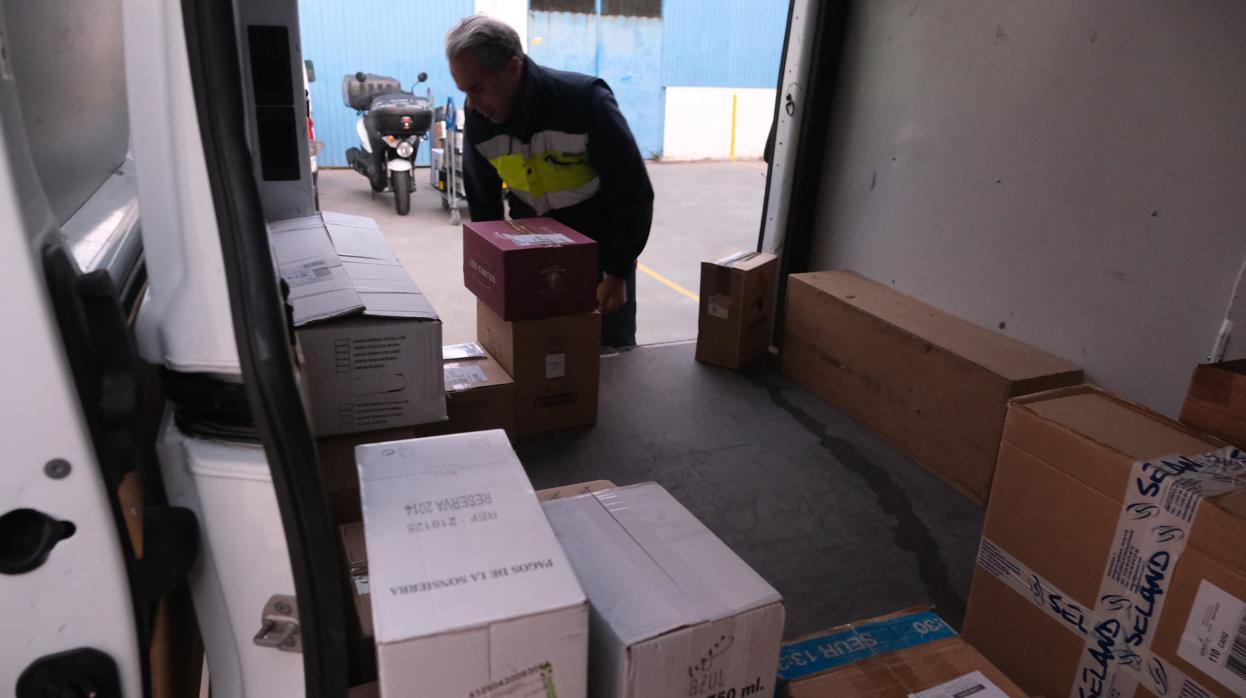 Un repartidor descarga cajas de su vehículo