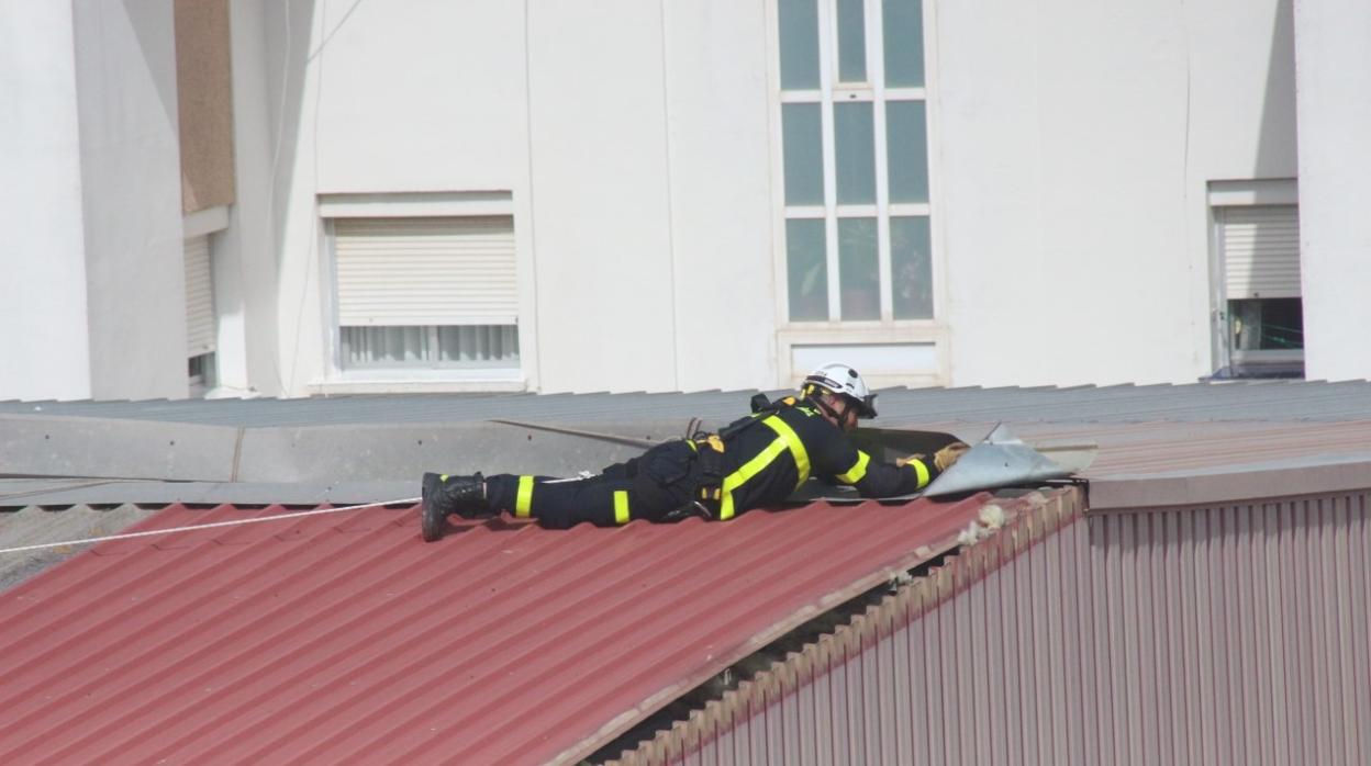 Un bombero trabaja sobre la cubierta del Pabellón Polideportivo Baruccio Caropo, en Medina Sidonia.