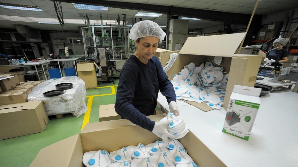 Una operaria introduce mnascarillas en una caja en una fábrica de Bilbao