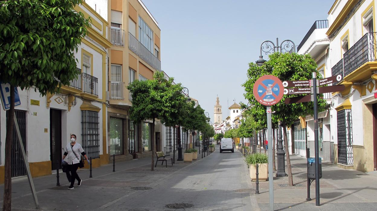 Una profesional del servicio de Ayuda a Domicilio camina hacia su trabajo por una solitaria calle Corredera