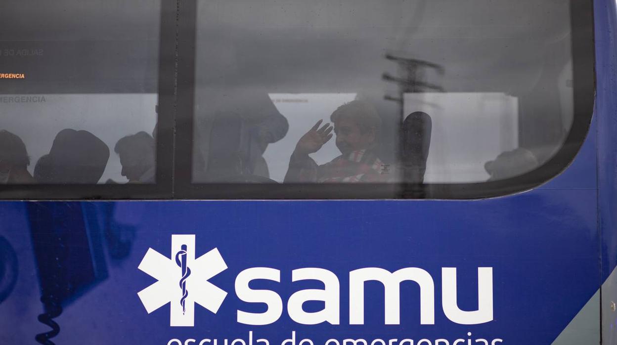 Una anciana saluda desde el autobús del SAMU a su llegada a La Línea.