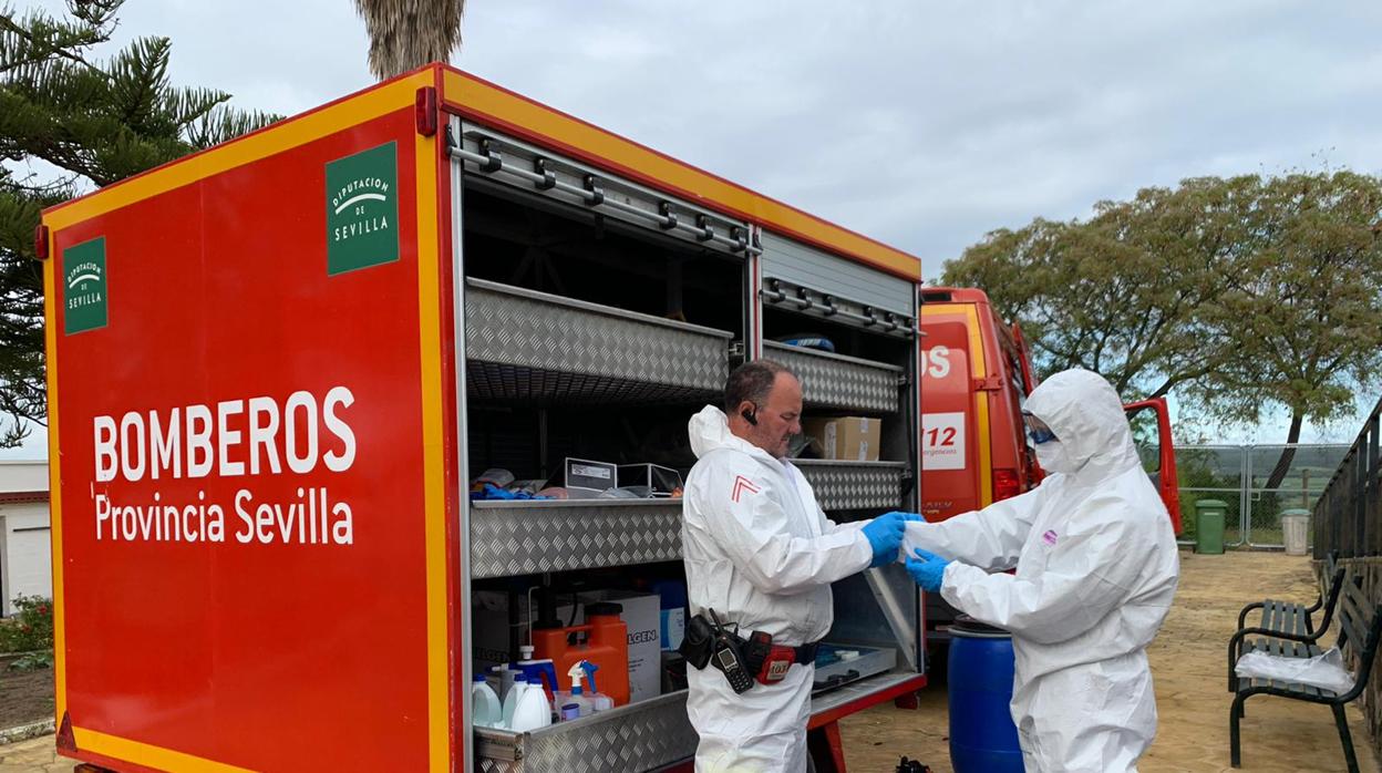 Dos bomberos de la Diputación de Sevilla se preparan para desinfectar un parque público
