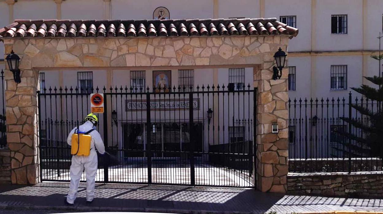 Un bombero desinfecta en la entrada de la residencia de ancianos de Ubrique.