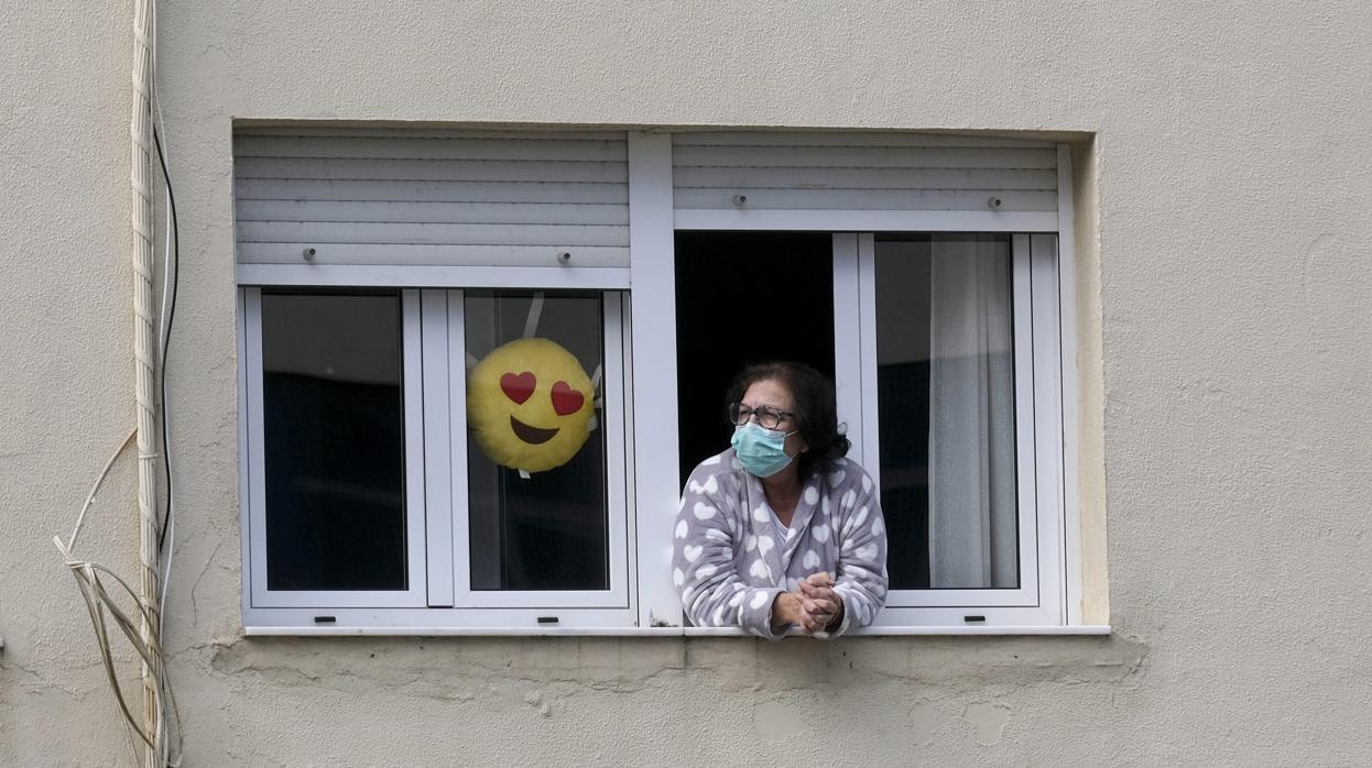 Una señora asomada a la ventana durante el confinamiento.