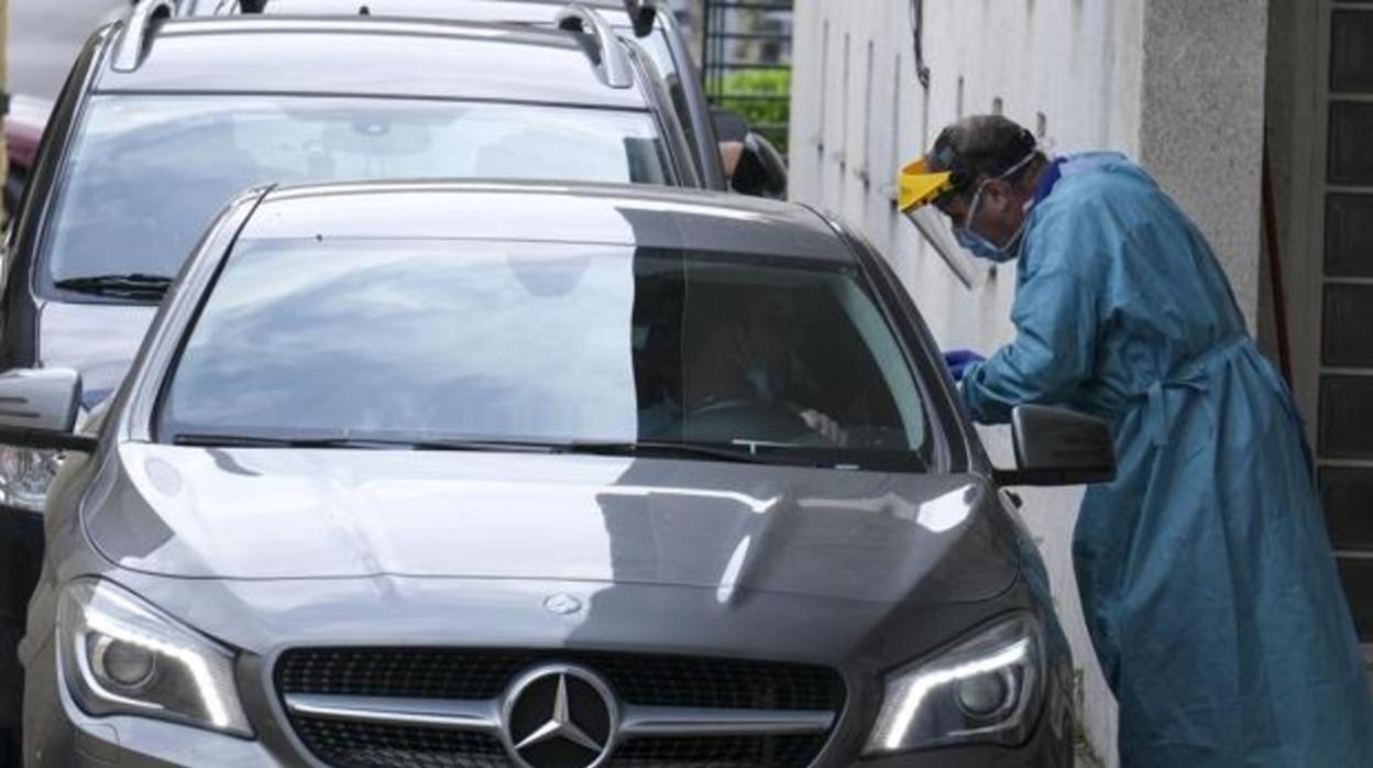 Decenas de coches esperan para que los trabajadores sean sometidos a las pruebas contra el coronavirus.