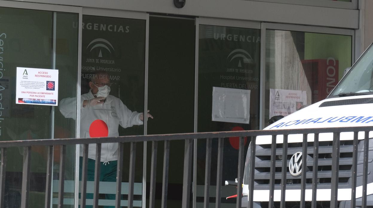 Un profesional del Hospital Universitario Puerta del Mar de Cádiz, cierra la puerta de Urgencias