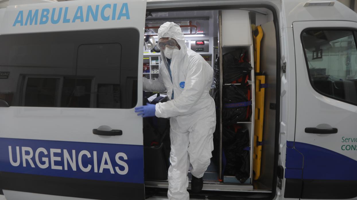 Un técnico auxiliar baja de la ambulancia con el Equipo de Protección Individual (EPI).