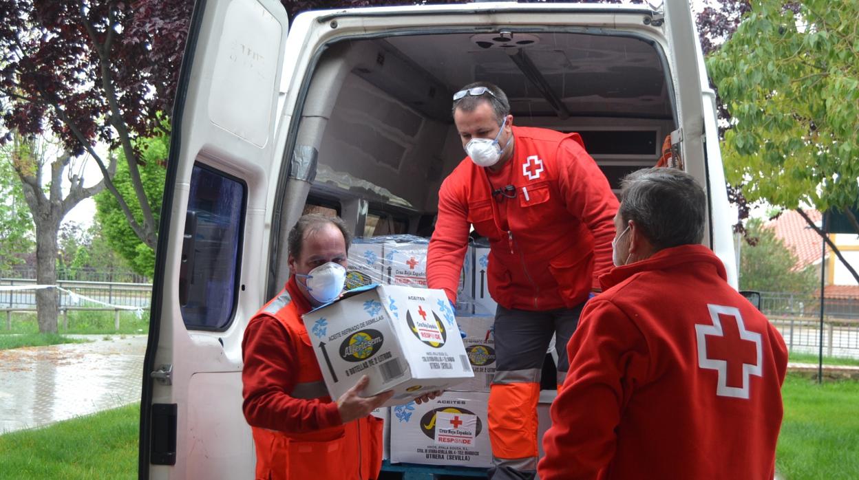 Tres voluntarios de Cruz Roja Sevilla se disponen a repartir alimentos en un pueblo de Sevilla