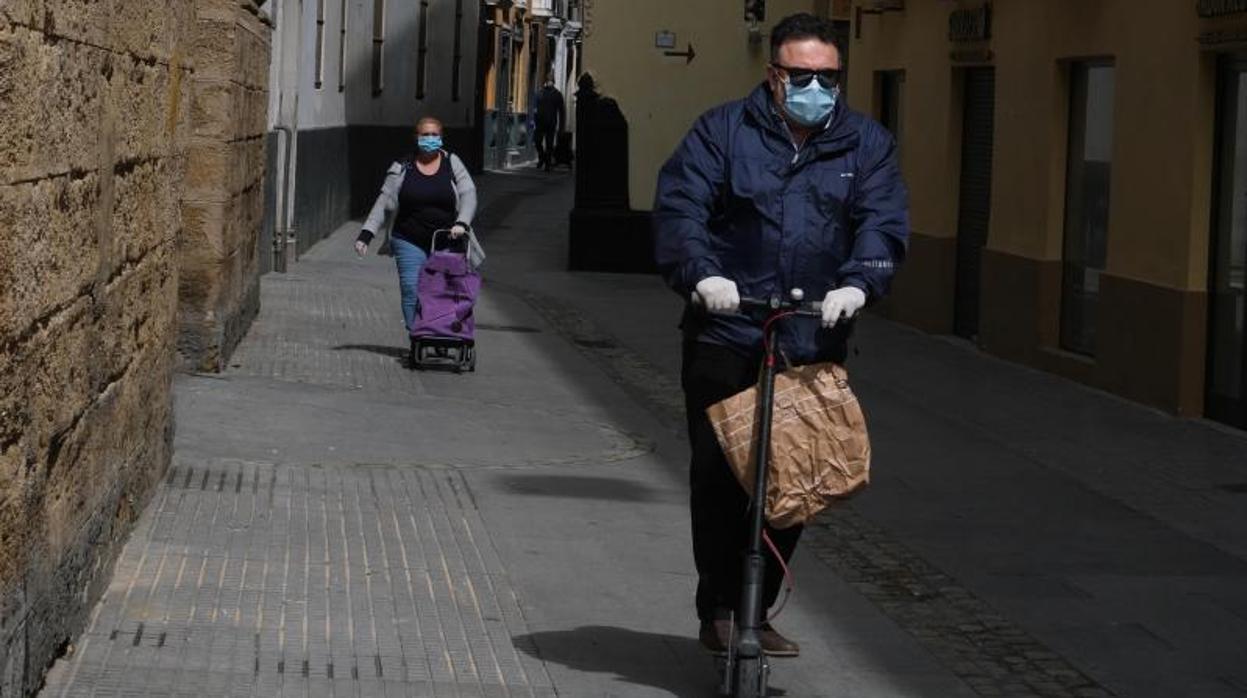 Los gaditanos salen a la compra protegidos con mascarillas y guantes.