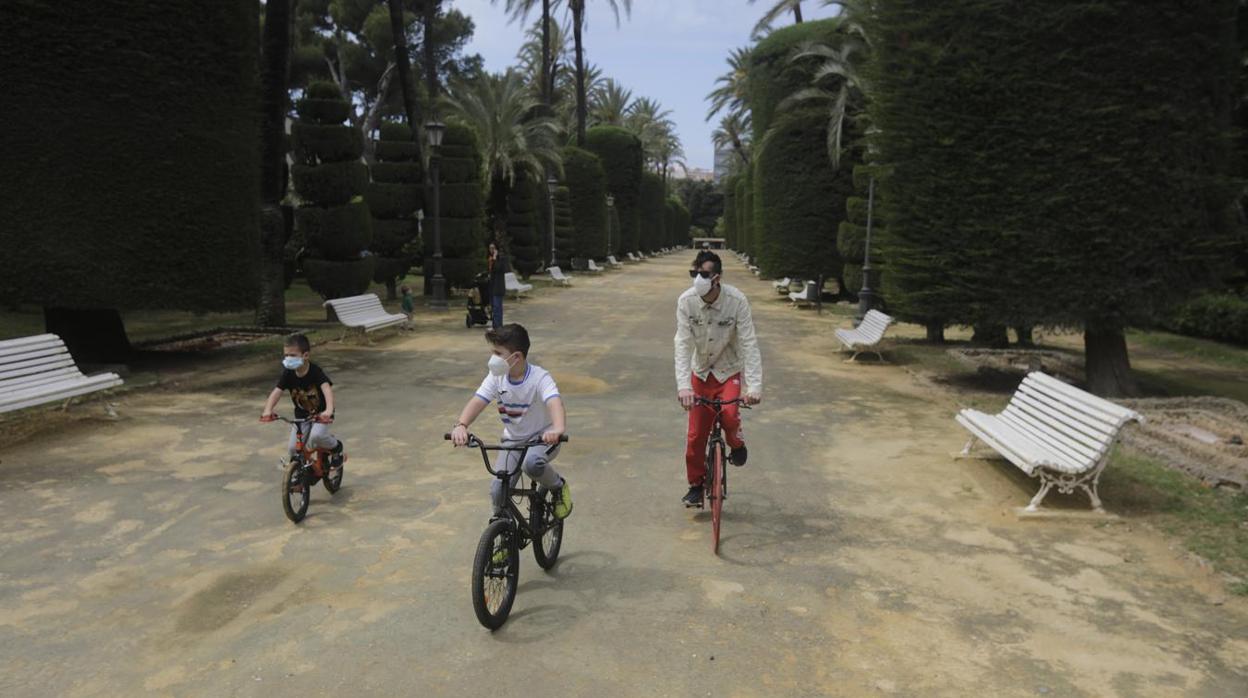 Un padre monta en bici con sus hijos en Cádiz tras permitirse las salidas de una hora.