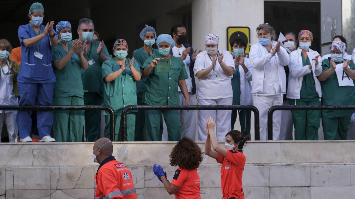 Sanitarios del Puerta del Mar y un equipo del 061 cruzan aplausos a la entrada del hospital gaditano.