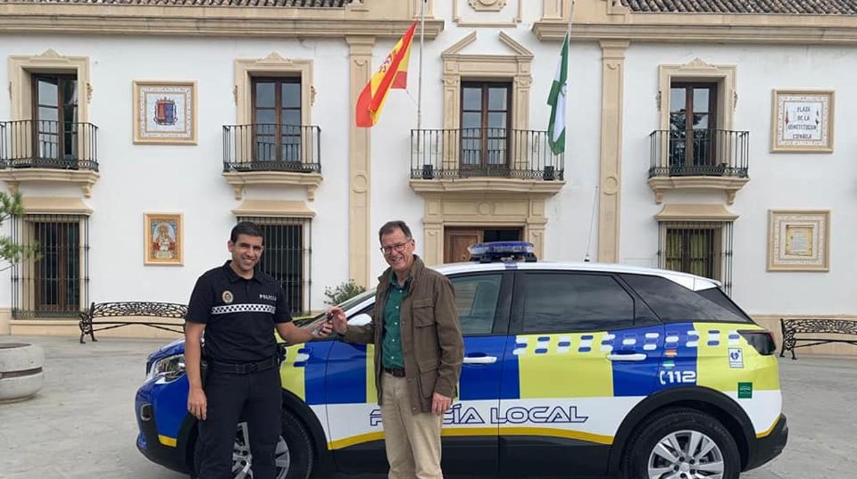 El alcalde de Burguillos, Domingo Delgado, junto a un agente de la Policía Local en la entrega de un coche patrulla