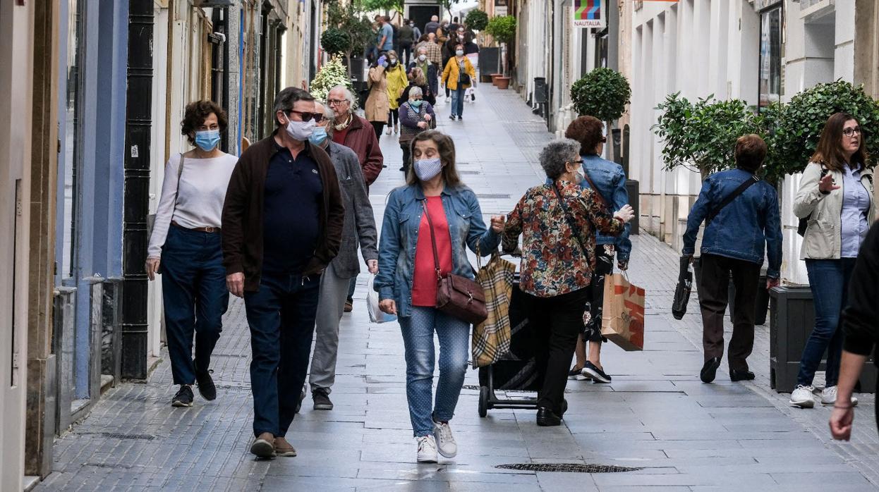 Personas con mascarilla paseando por una calle de Cádiz.