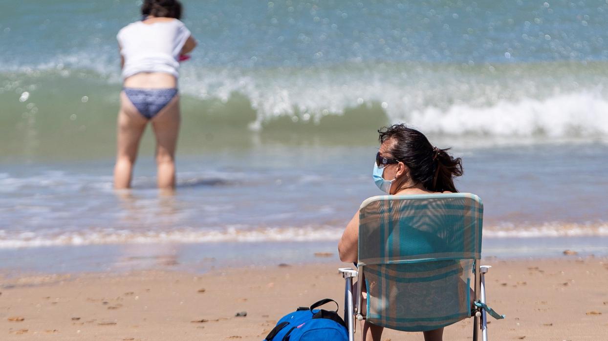 La mascarilla se ha convertida en una prenda de vestir, includo en la playa.