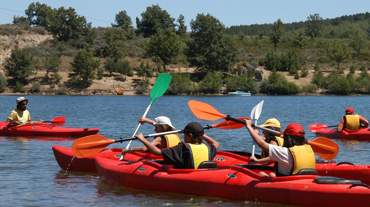 Un grupo de niños practican deportes acuáticos en una actividad de un campamento de verano