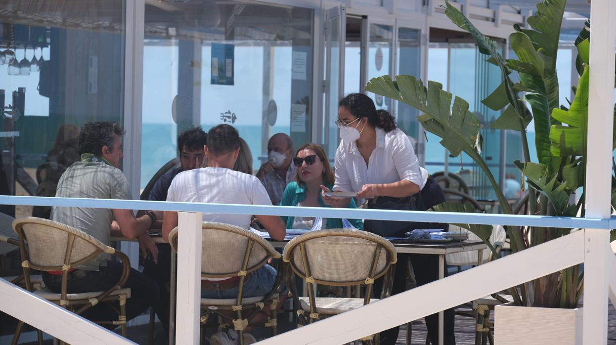 Varios clientes sentados en una terraza de un restaurante de Cádiz.