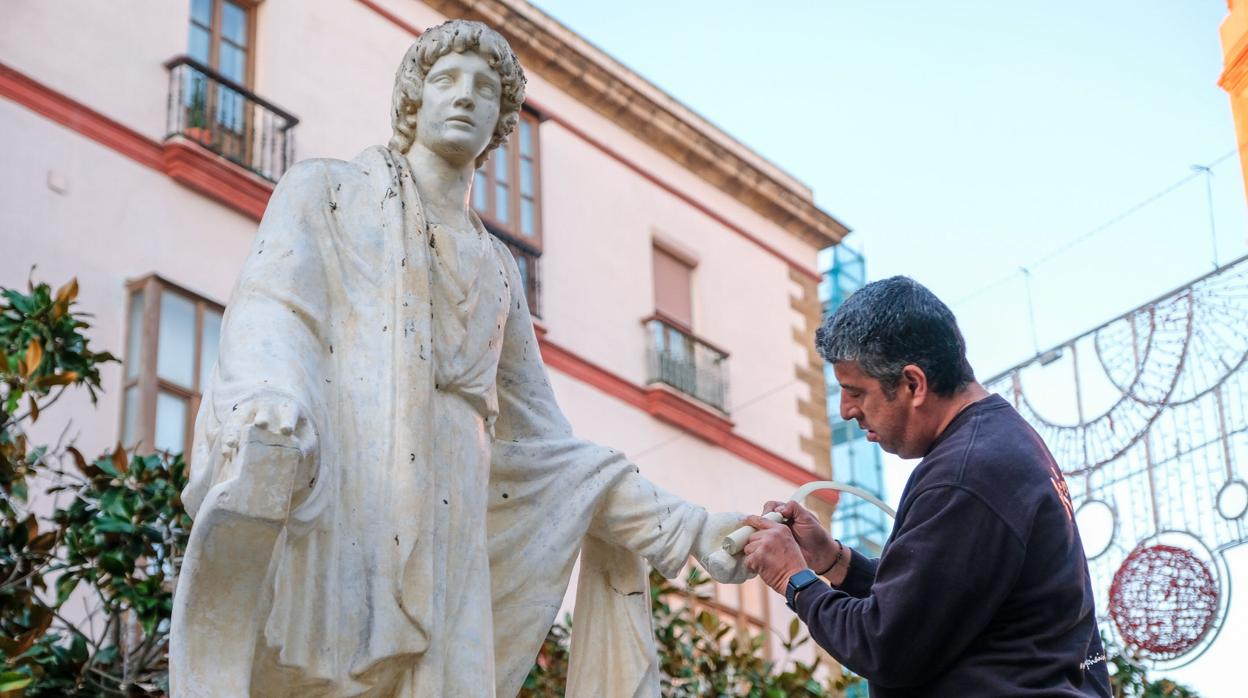 Un operario remata la reparación de la estatua de Columela en el centro de Cádiz.