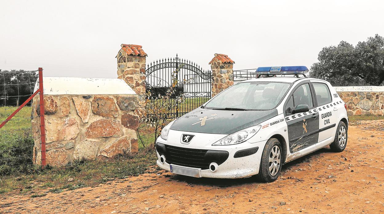 Un coche de la Guardia Civil delante de la entrada de la finca La Lapa en Guillena donde ocurrieron los hechos