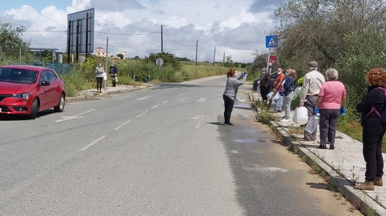 Cola de parcelistas para recoger agua de un grifo habilitado por Aljarafesa ante la sequía de los pozos