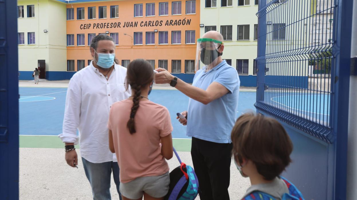 Un maestro toma la temperatura a su alumna a la entrada del CEIP Profesor Juan Carlos Aragón, en Cádiz capital.