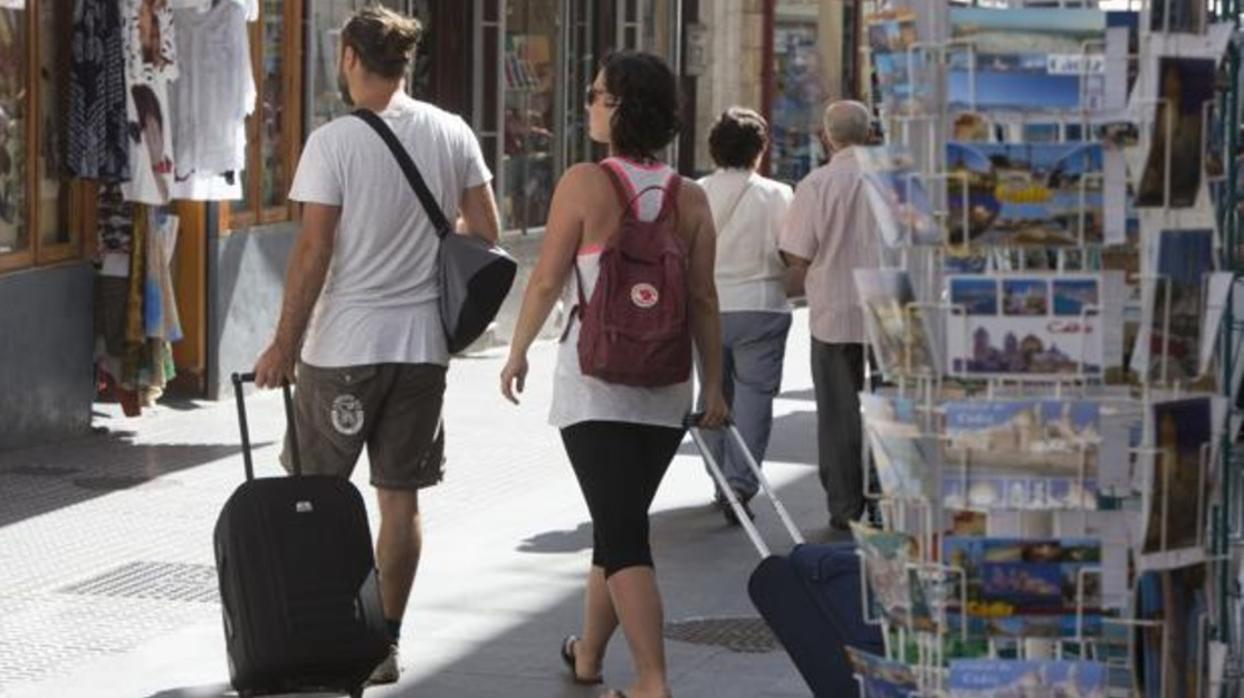 Turistas de visita en Cádiz pasean por el casco histórico.