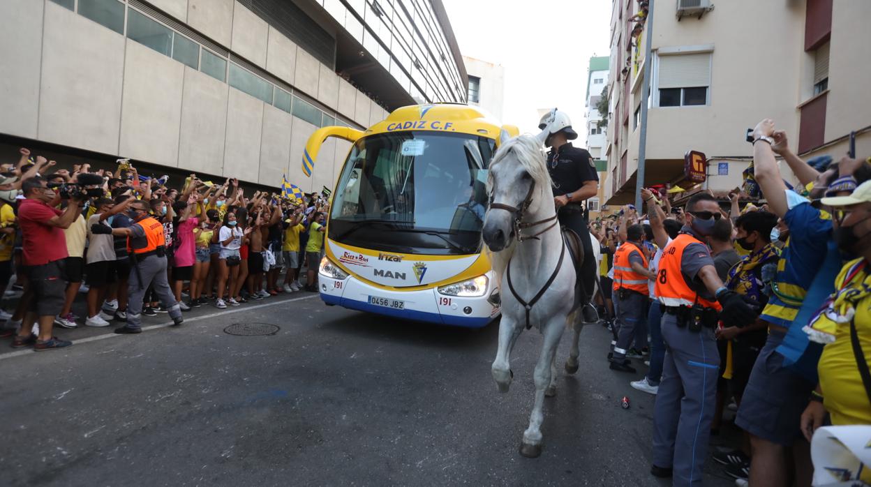 Un agente de Caballería custodia la llegada del autobús ante la aglomeración de cientos de aficionados.