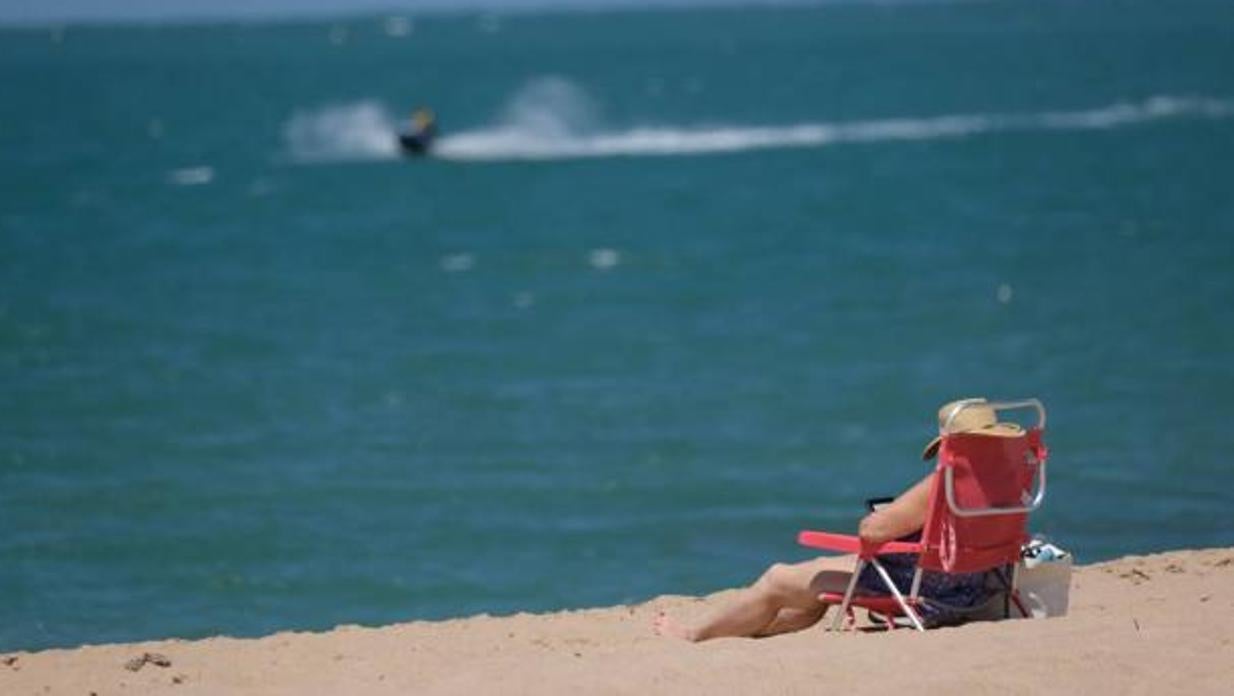 Una mujer disfruta de la playa de la Costilla, en Rota.