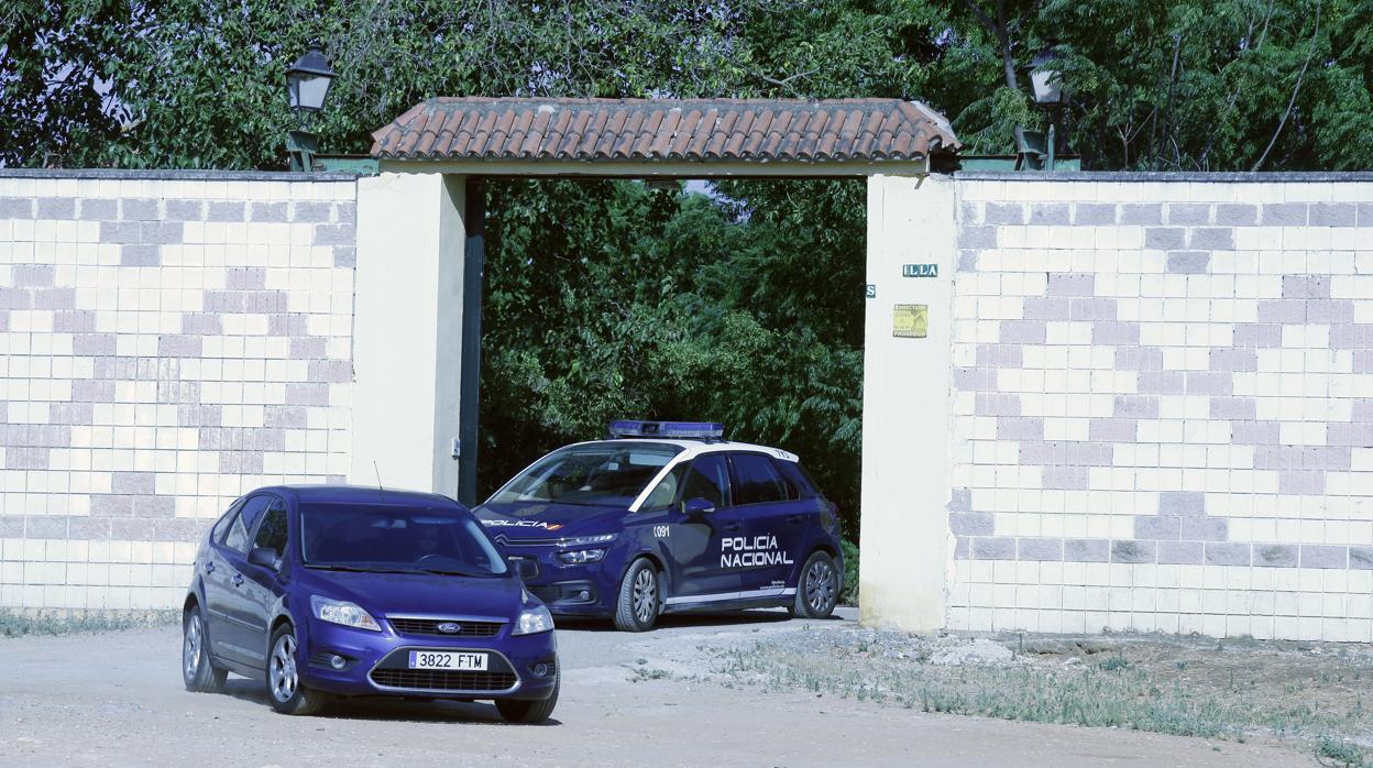 Dos coches policiales abandonan la finca donde vivían las víctimas y su presunta asesina