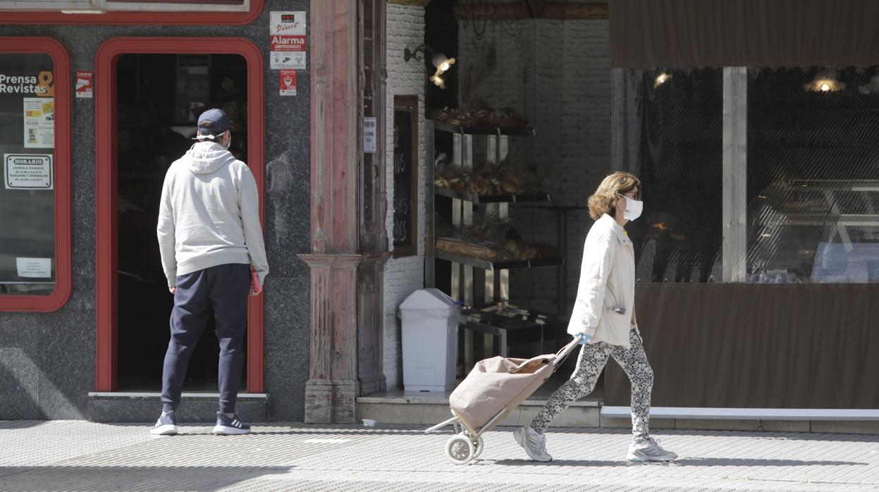 Una mujer pasea con mascarilla por las calles de Cádiz.