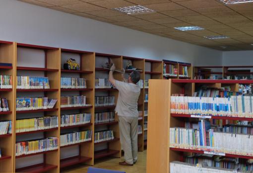 Uno de los bibliotecarios colocando nuevo material en las estanterias