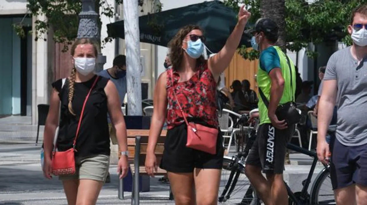 La gente pasea en Cádiz con la mascarilla obligatoria para protegerse de contagios.