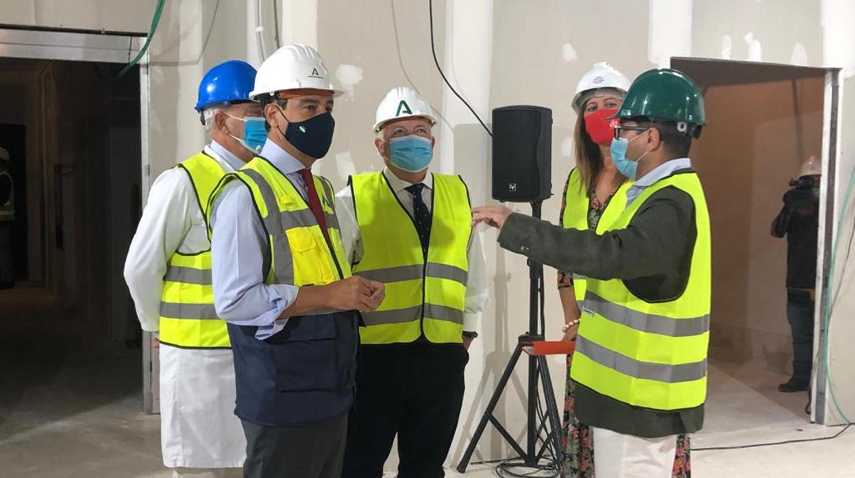 Juanma Moreno atiende las explicaciones del director de las obras de la reforma del Hospital La Merced de Osuna