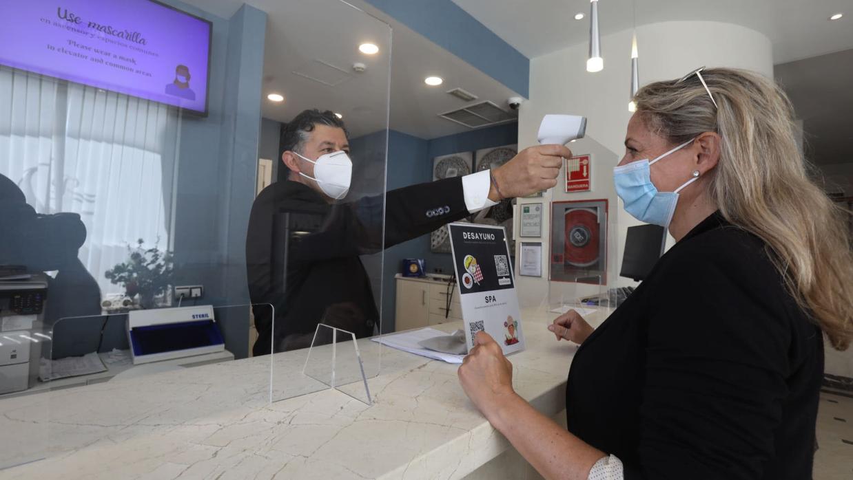 Toma de temperatura a una clienta realizada en la recepción de un hotel de Cádiz