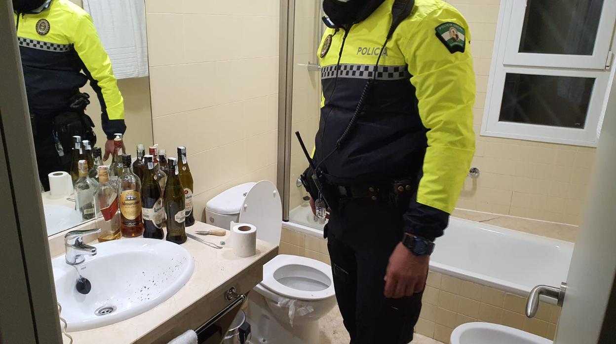 Un agente de la Policía Local de Bormujos en el interior de la habitación de un hotel donde se celebraba un botellón