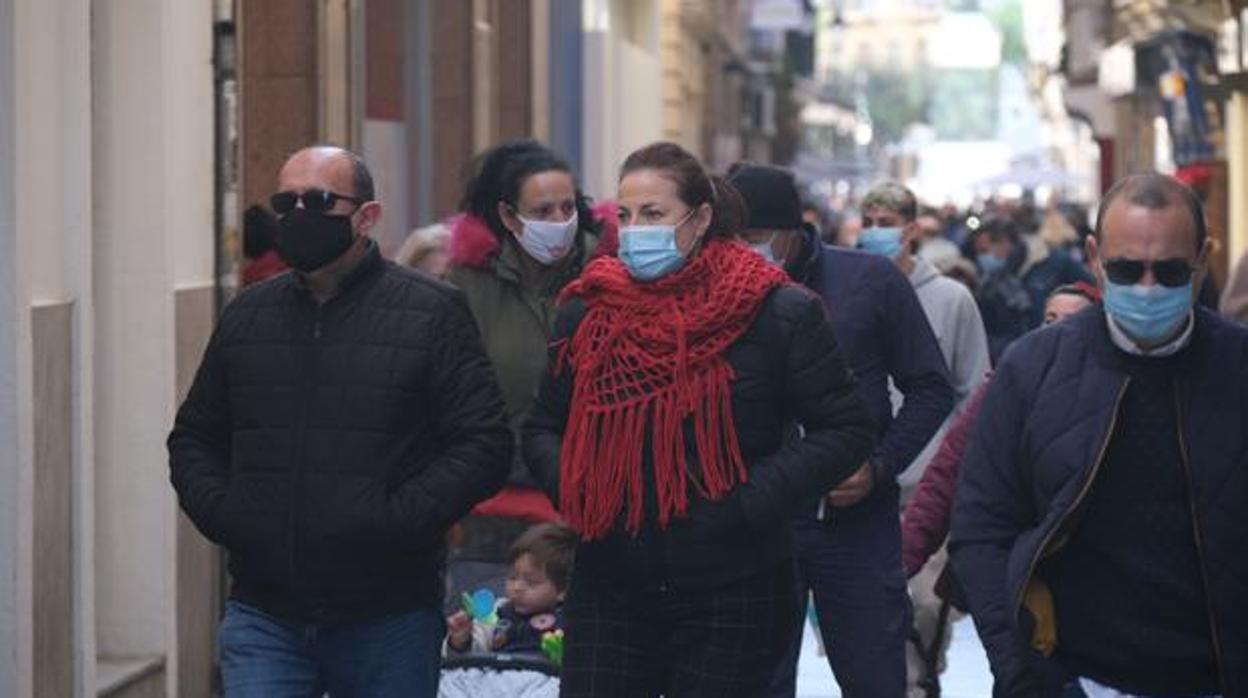 Los ciudadanos pasean por las calles de Cádiz ataviados con ropa de abrigo para combatir el frío.