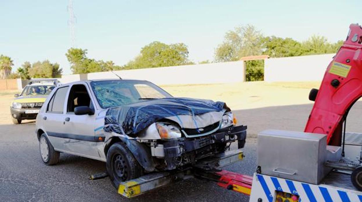 Una grúa retira el coche de la detenida de la finca donde residía, junto a las víctimas, en Dos Hermanas