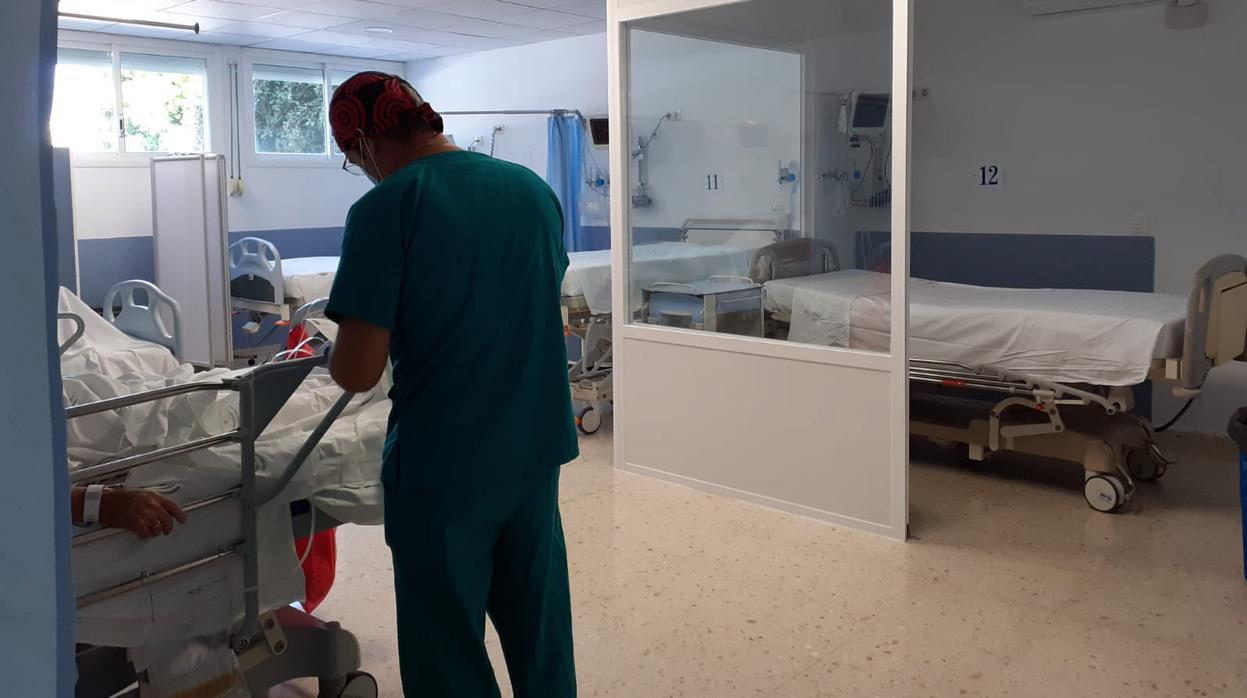 Un sanitario atiende a un paciente ingresado en el Hospital de Puerto Real.