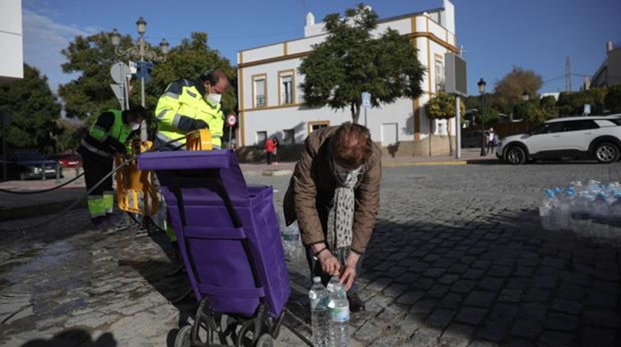 Una vecina de Marchena recoge agua del camión cisterna habilitado durante la crisis del benceno en el mes de diciembre de 2020