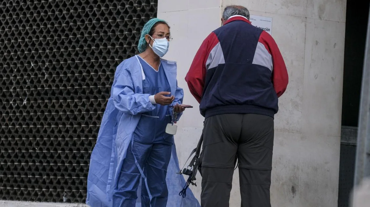 Una sanitaria ayuda a un usuario en el Puerta del Mar de Cádiz.