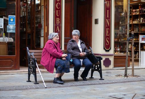 Dolores y María conversan ya sin mascarillas en un banco de Main Street