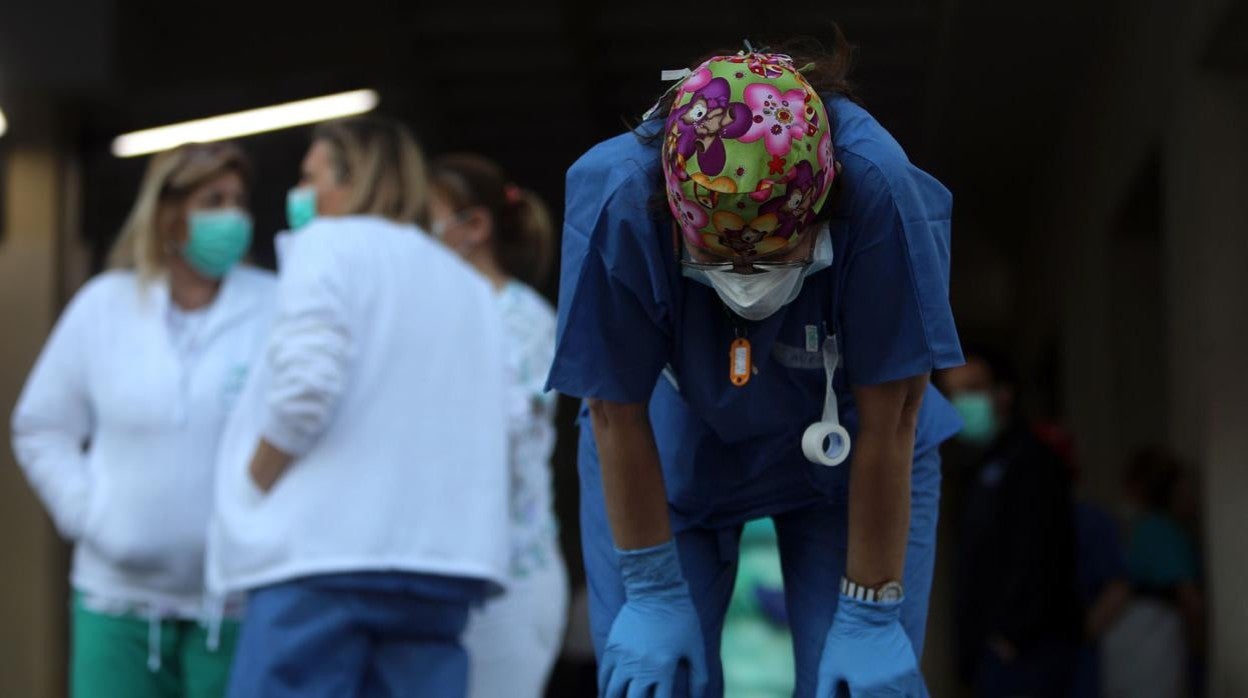 Una sanitaria, agotada en la entrada del Hospital Puerta del Mar.