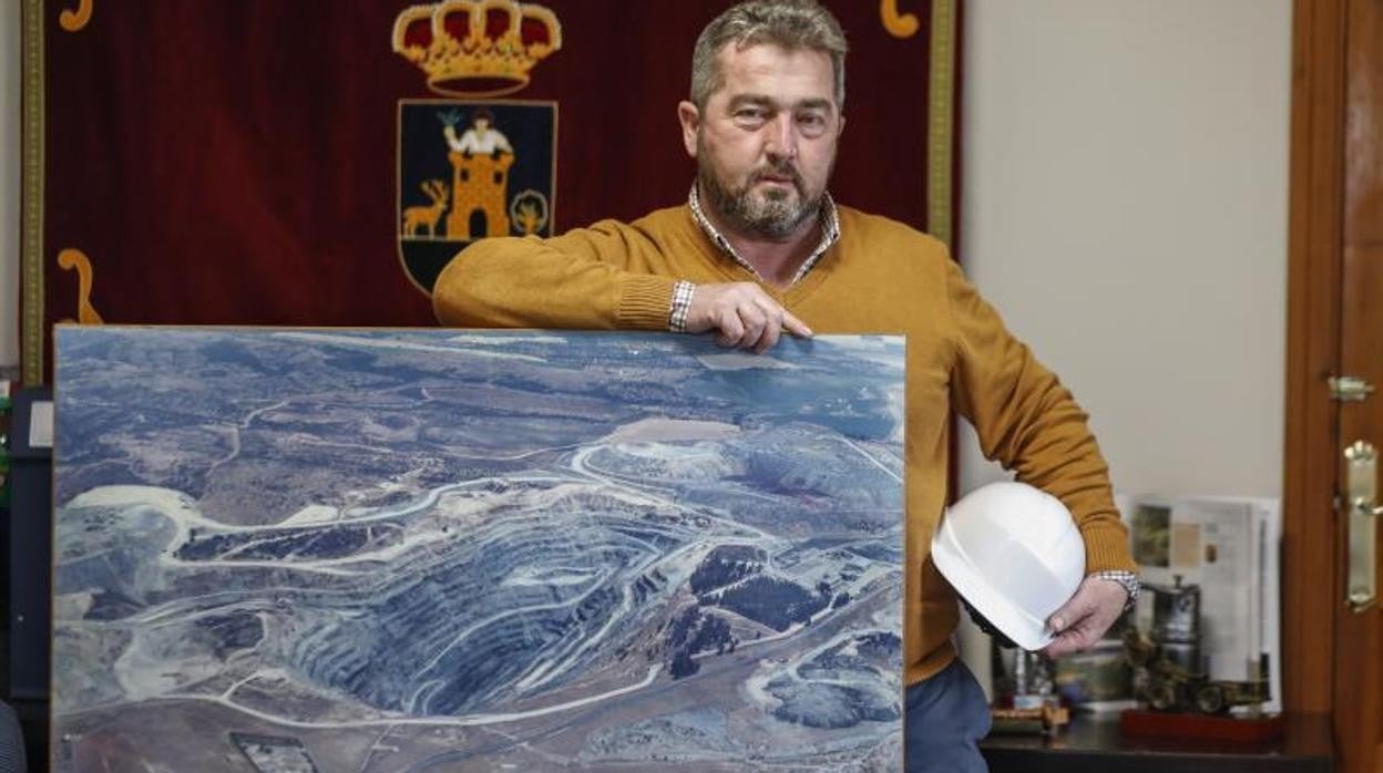 El alcalde de Aznalcóllar, Juan José Fernández, en su despacho junto a un cuadro de la mina y un casco