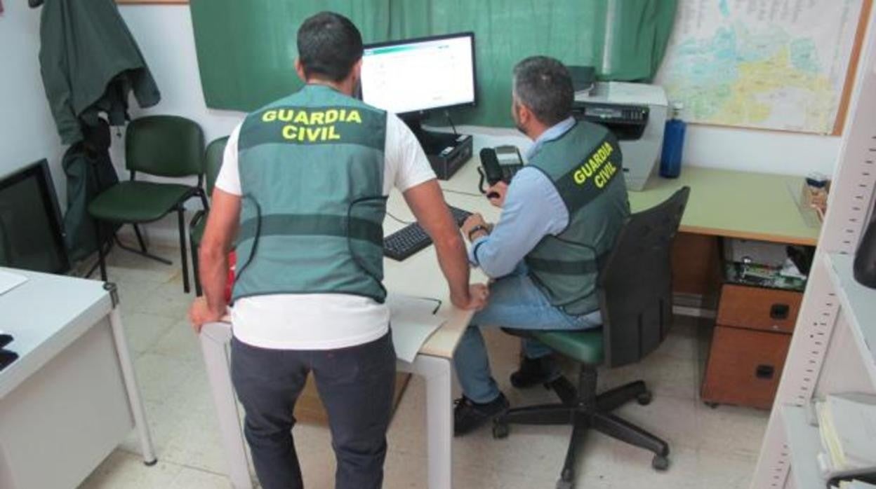 Dos agentes del puesto de Lebrija verifican información en una base de datos